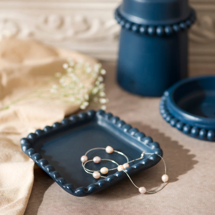 Handcrafted indigo terracotta trinket tray styled on a vanity holding jewelry and everyday essentials.