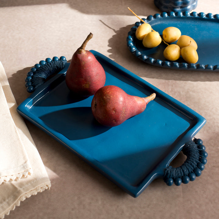 Handcrafted terracotta serving tray styled with appetizers and artisan tableware for an elegant dining presentation.