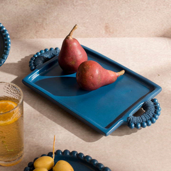 Handcrafted terracotta serving tray styled with appetizers and artisan tableware for an elegant dining presentation.