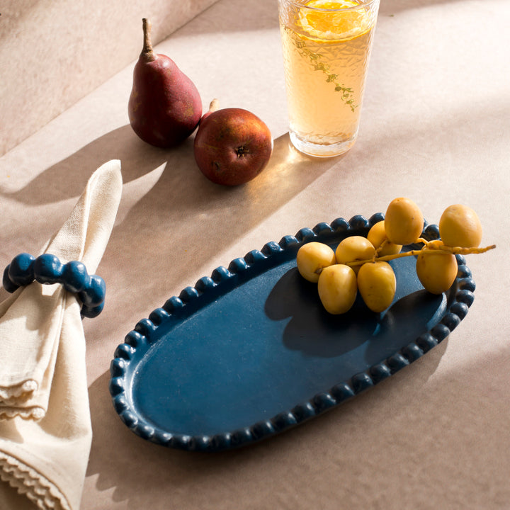 Handcrafted terracotta serving platter styled with cheeses, fresh fruit, and appetizers on an artisan-inspired dining table.