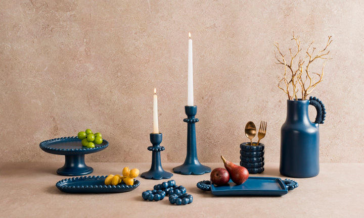 Handcrafted terracotta pedestal cake stand styled with desserts and artisan table décor for an elegant dining presentation.