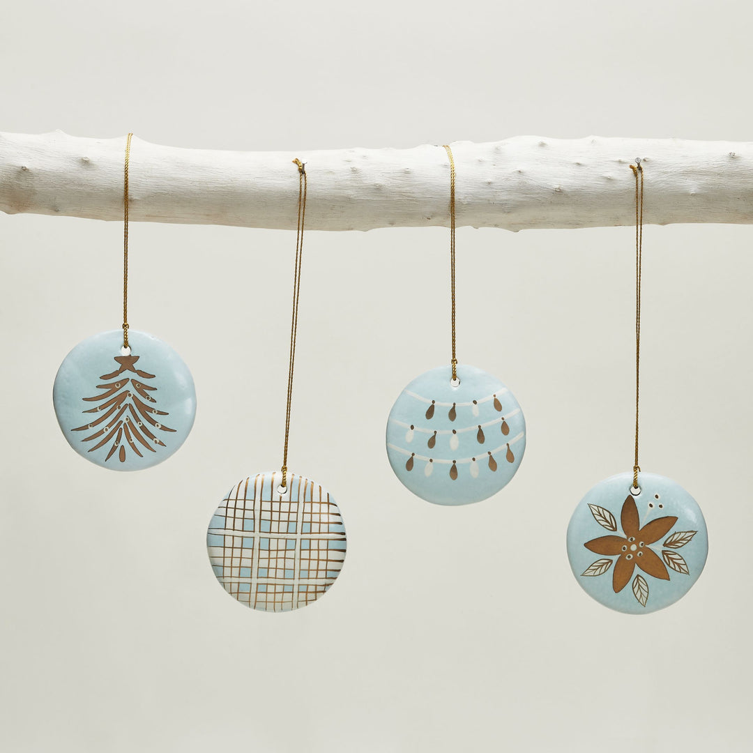 Close-up of hand-painted blue paper mache Christmas ornament with red green and gold holiday design
