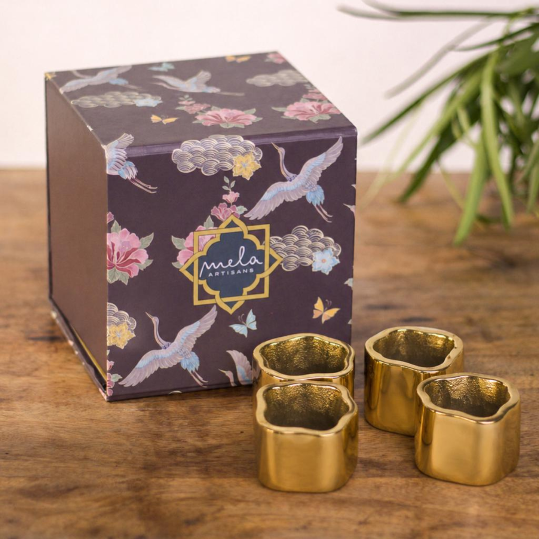 Set of four thick, sculpted gold napkin rings with a modern hexagonal-inspired shape.