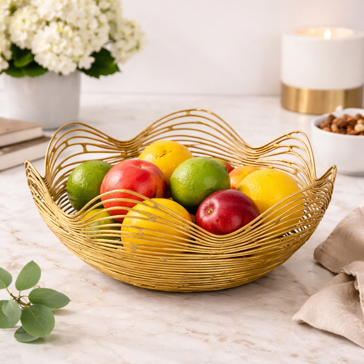 gold metal fruit bowl styled on dining table with fruits
