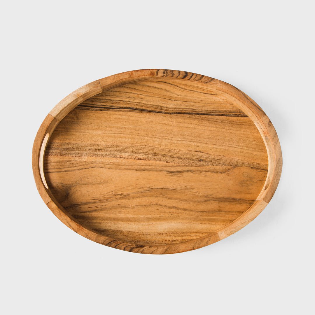 Close-up of natural acacia wood grain and carved handle detail on oval tray