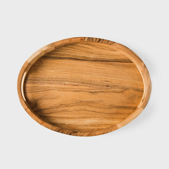 Close-up of natural acacia wood grain and carved handle detail on oval tray