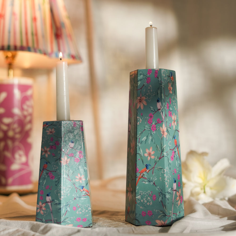 Aqua Flora candleholders styled on a table, casting a warm glow with lit taper candles.