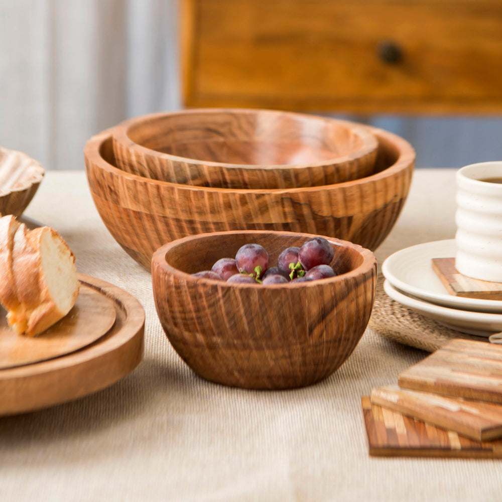 Wooden bowls styled with fruits and salads on dining table