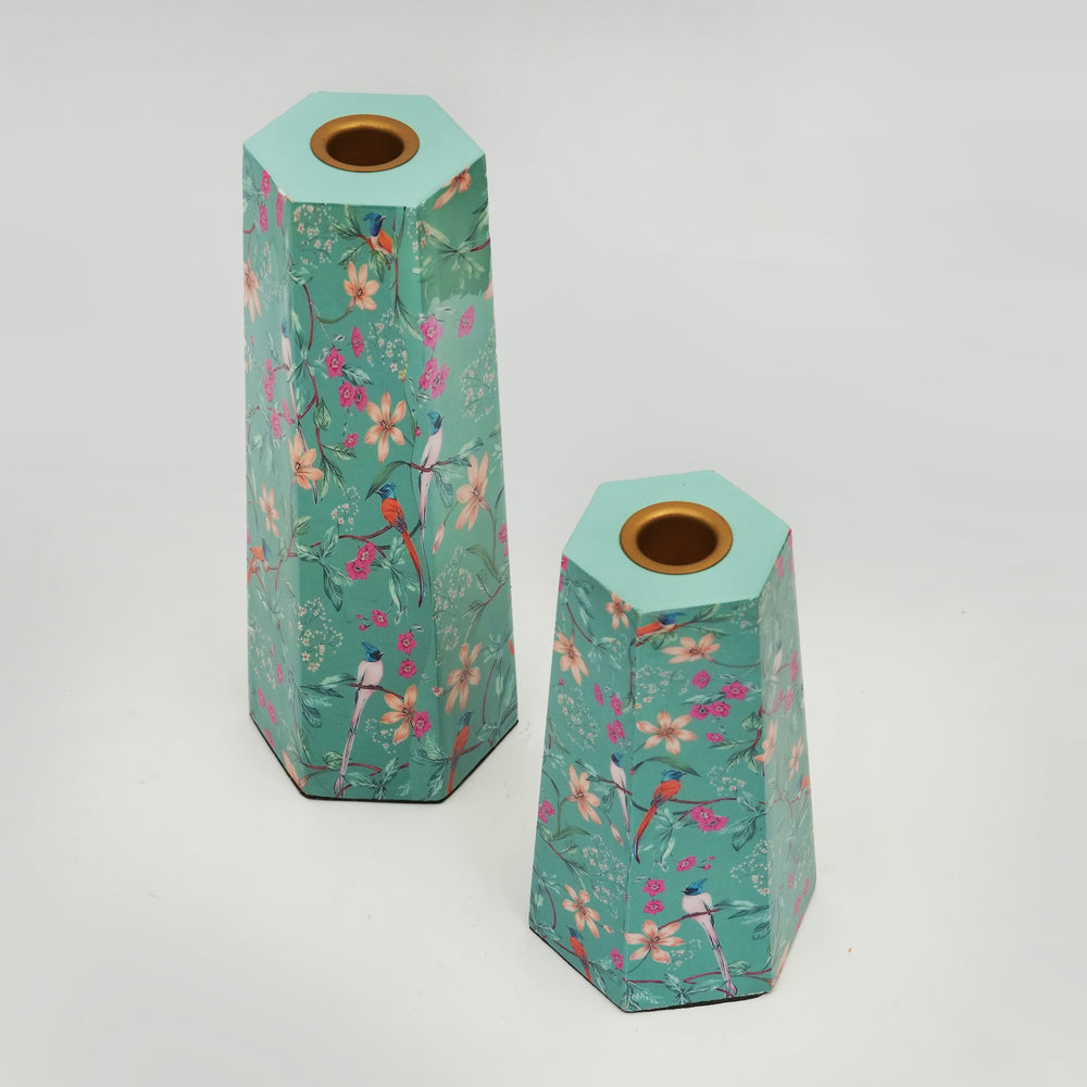 Pair of hexagonal aqua candleholders with pink floral enamel and wood-rimmed tops.