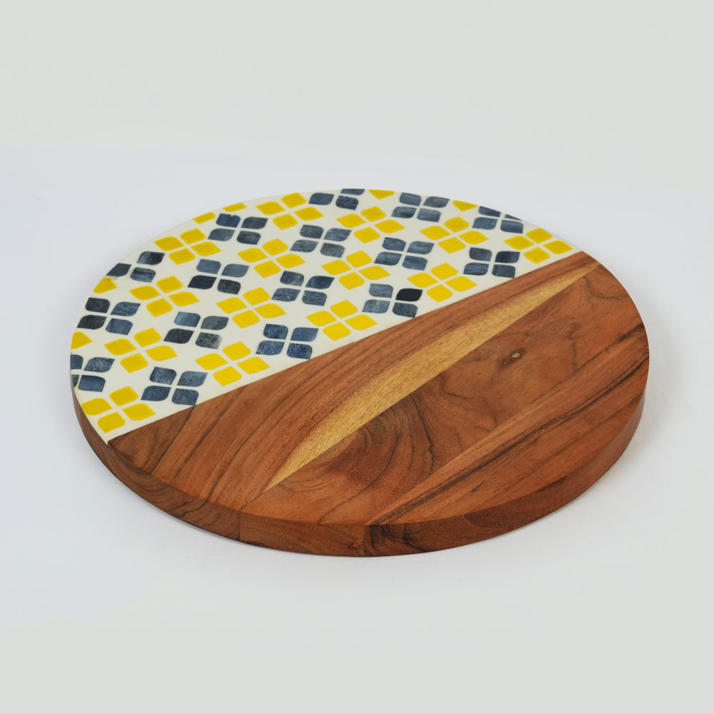 Overhead view of a 13-inch round acacia wood serve board featuring a vibrant yellow and white mosaic pattern.