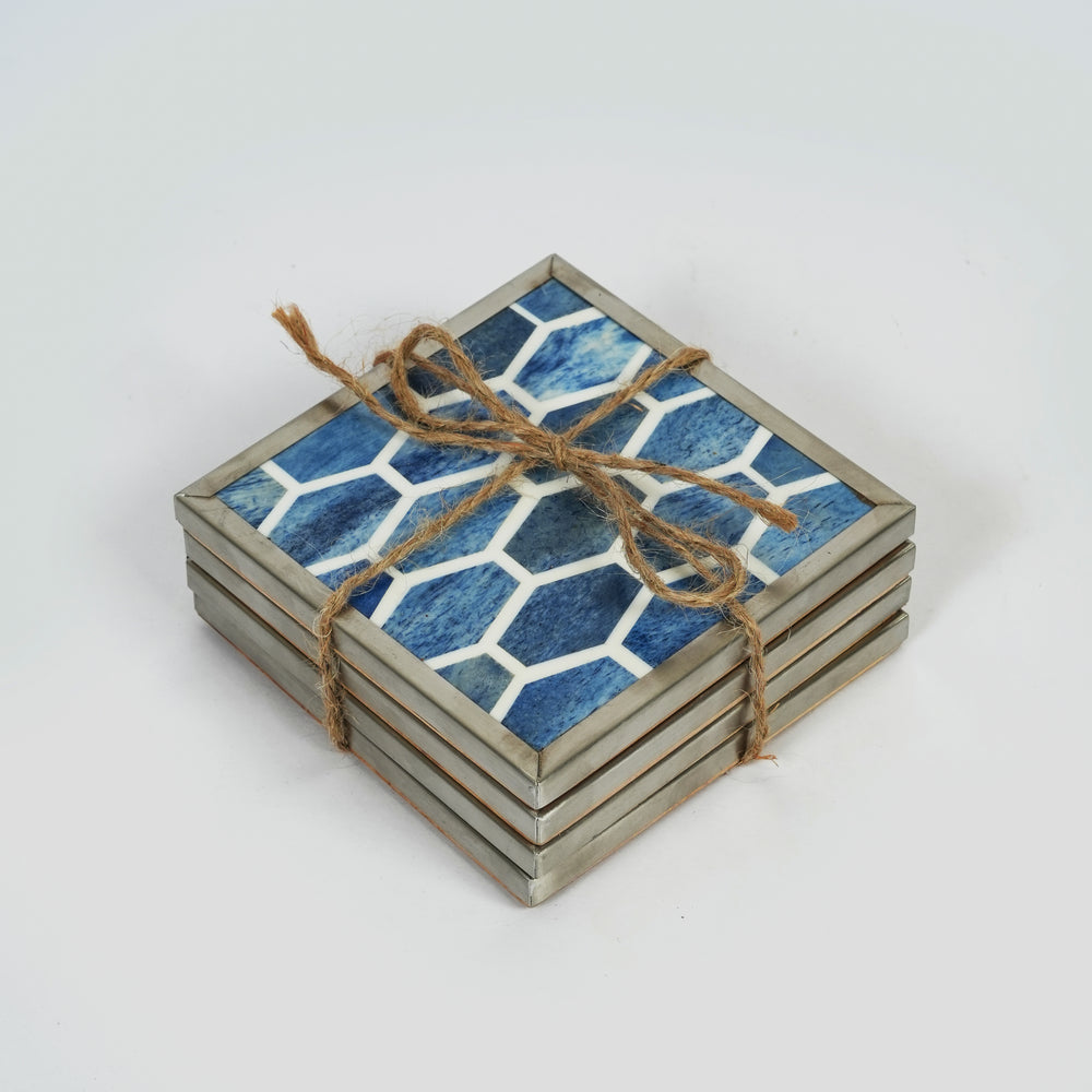Set of four handcrafted blue bone inlay coasters with an intricate white geometric honeycomb pattern, tied with a rustic twine bow.