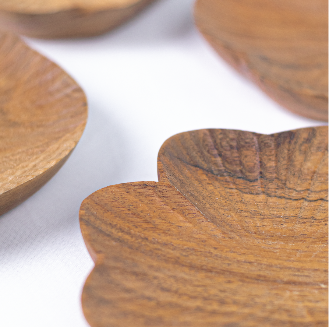  Close-up of hand-carved textured surface and natural wood grain on a scalloped wooden dish