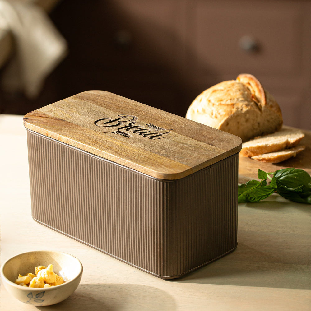 Wooden bread box on a kitchen counter with bread and butter