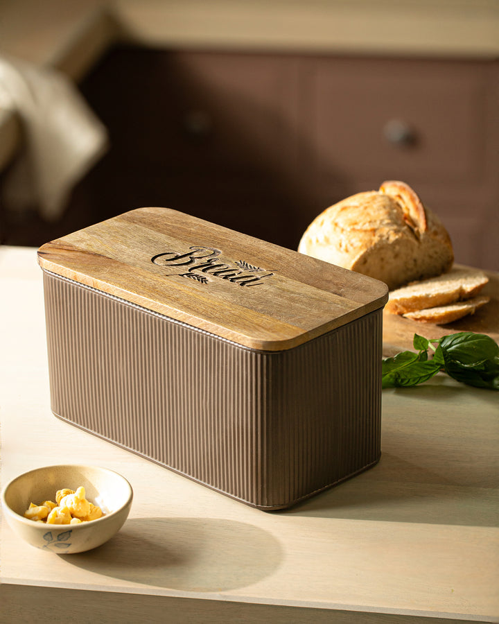 Wooden bread box on a kitchen counter with bread and butter