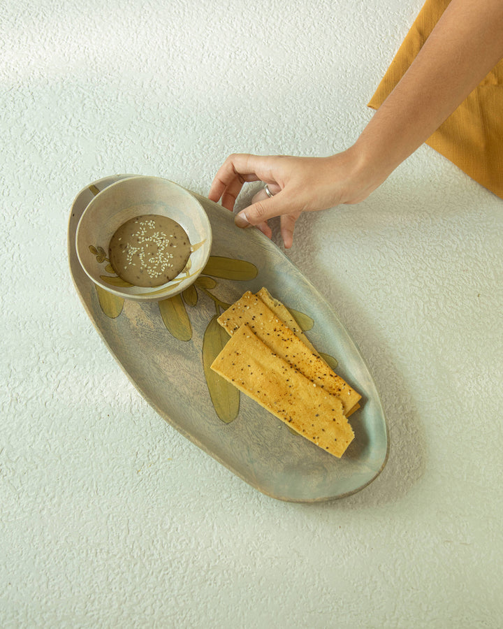 hand painted snack bowl styled with nuts on table
