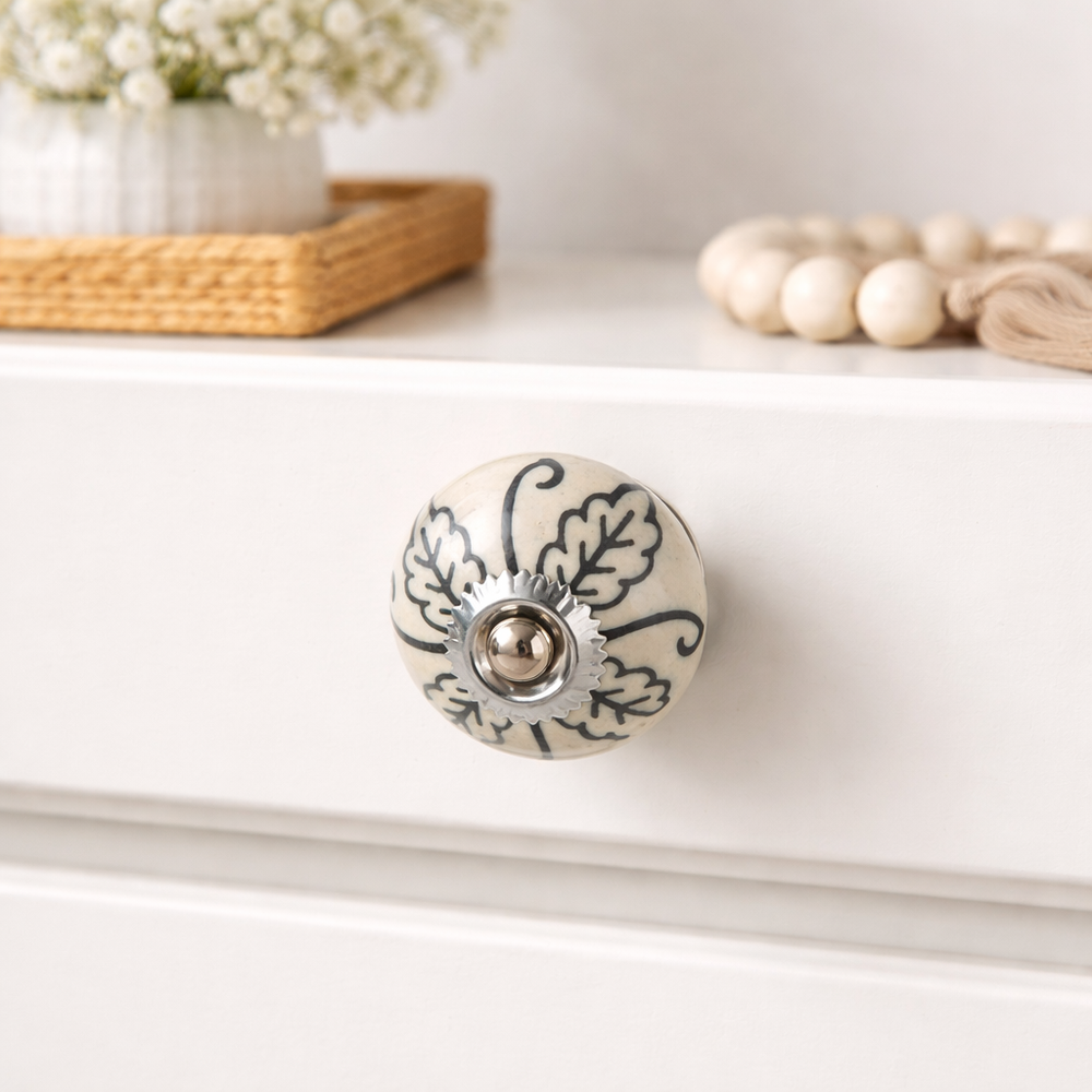 Painted ceramic knobs installed on wooden cabinet drawers in home interior