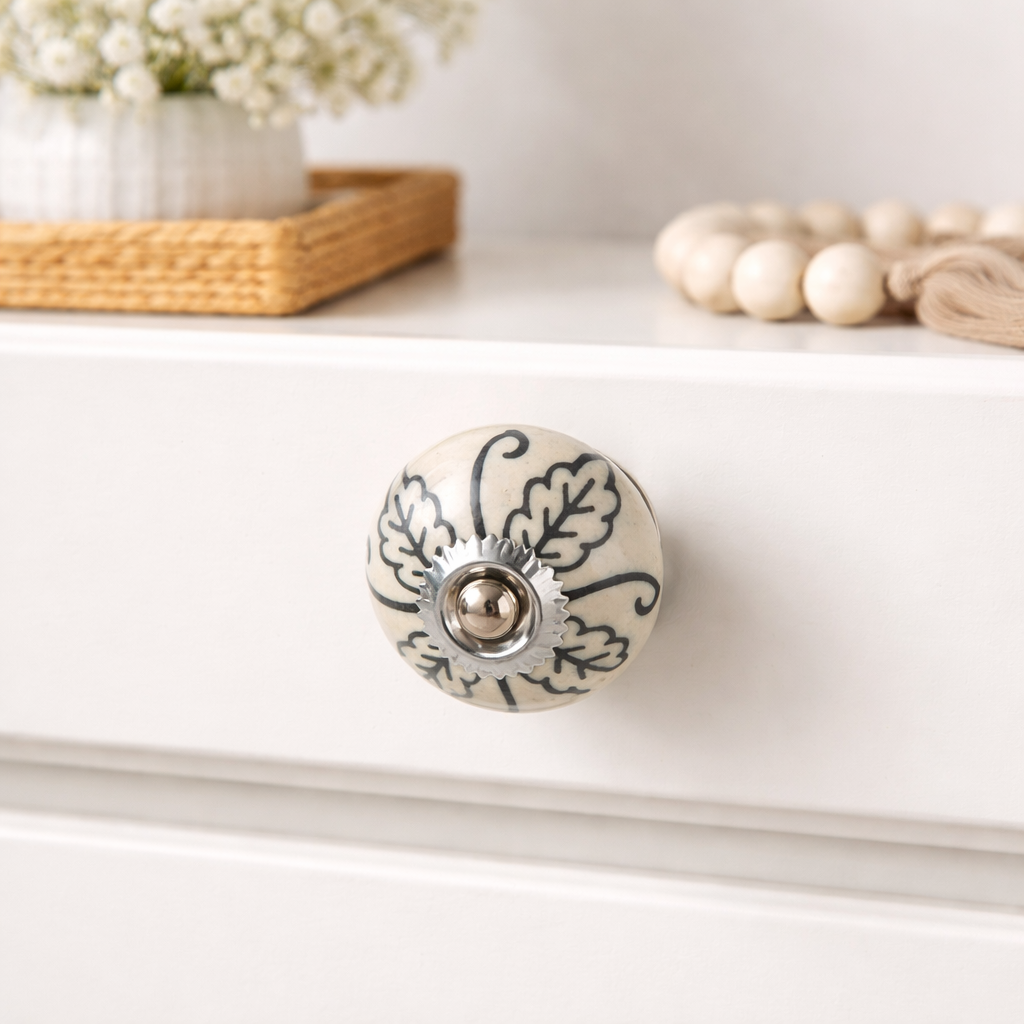 Painted ceramic knobs installed on wooden cabinet drawers in home interior