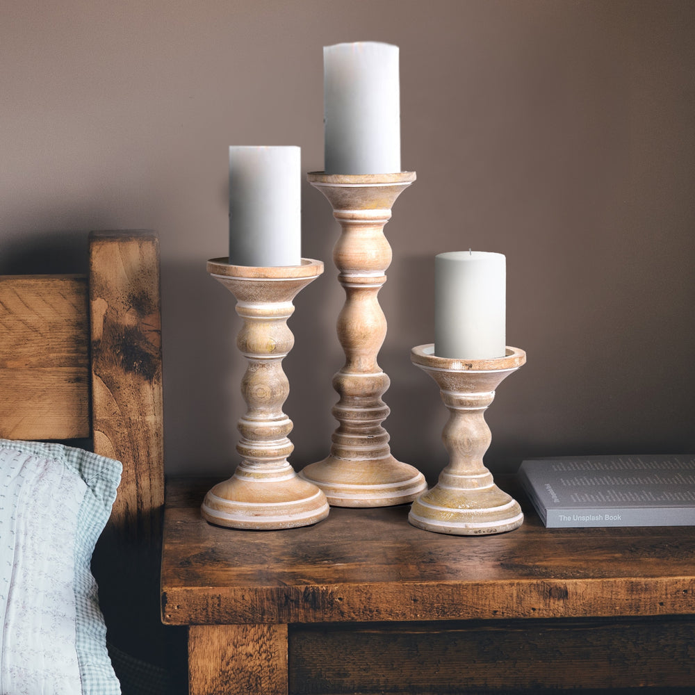 white candleholder set styled on table with candles